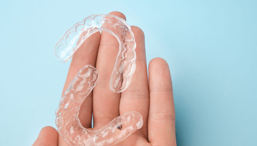 close up mans hand holding invisible aligners for 2021 09 30 20 49 58 utc 1 scaled e1672579582743